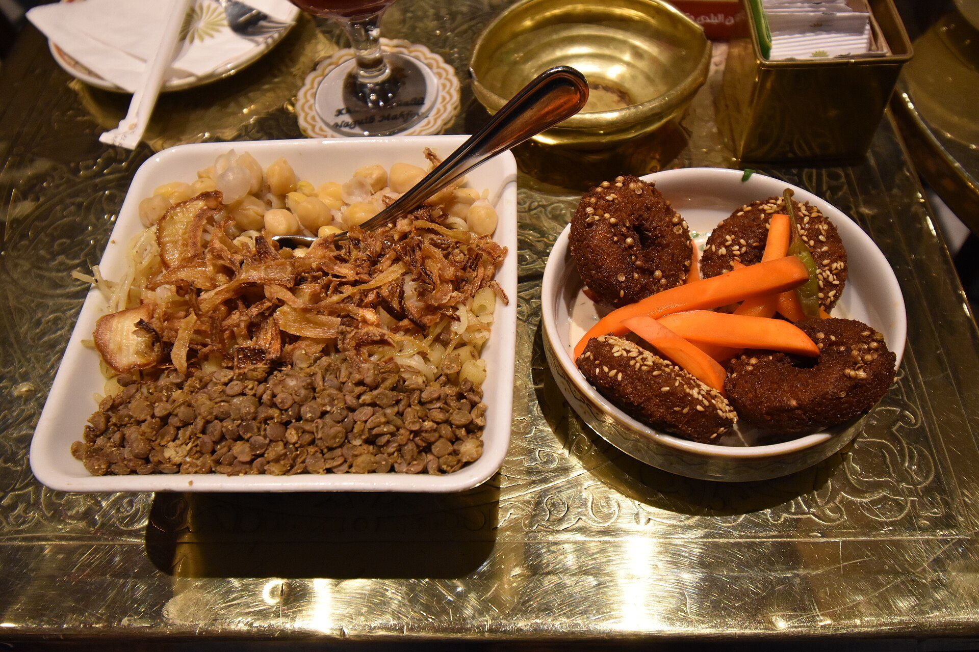 A bowl of koshary with falafel on the side in Cairo